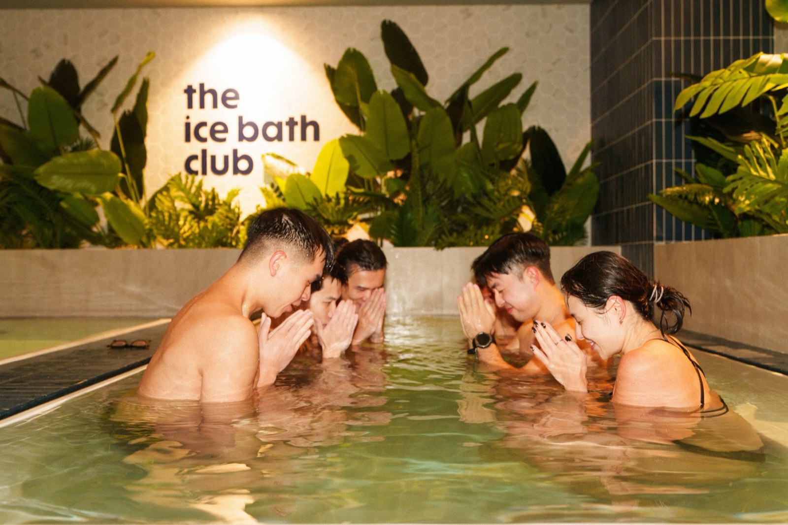 Friends in the ice bath under The Ice Bath Club sign at Central, Hong Kong