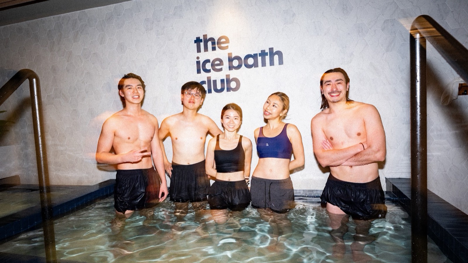 Friends standing in the ice bath under The Ice Bath Club sign at Kennedy Town, Hong Kong