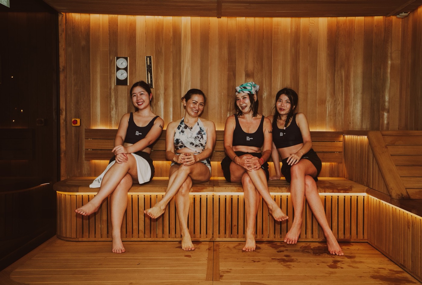 Four friends relaxing together on the sauna benches at Nana, Bangkok