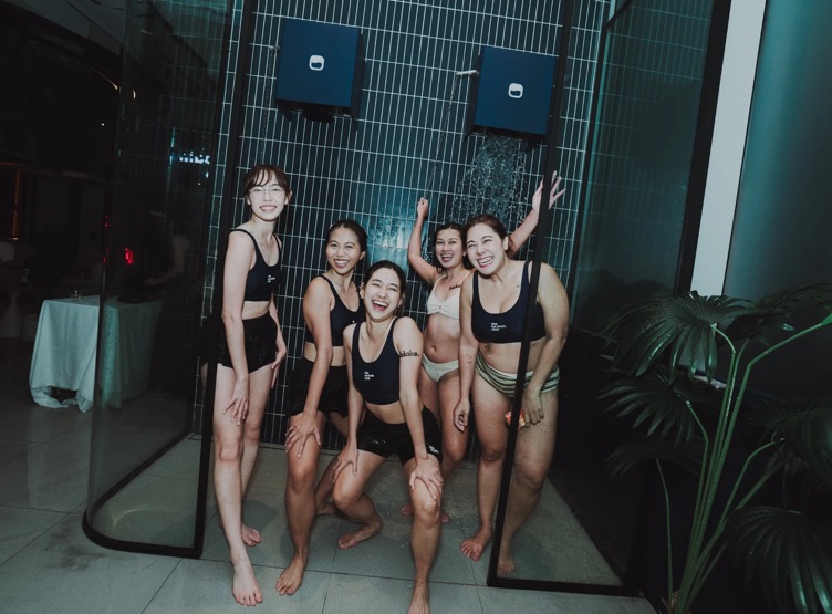 Five friends laughing under the ice showers