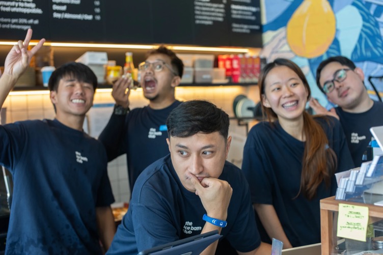 The team clowning around behind the café counter