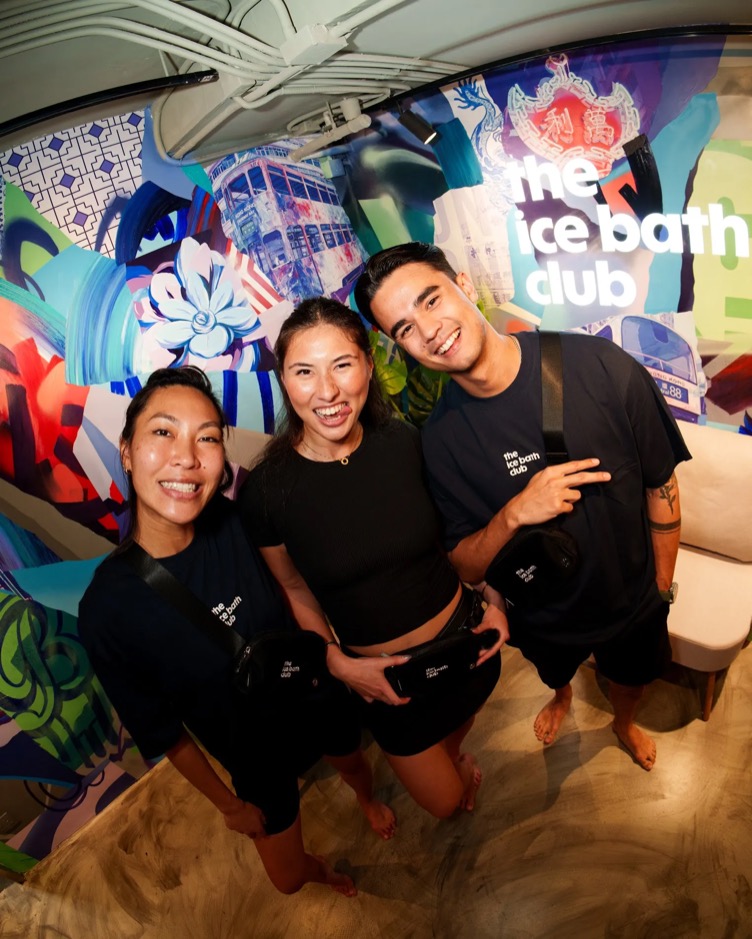 Three members in front of the Hong Kong mural