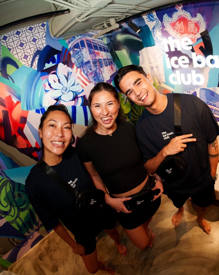Three of the team in front of the Hong Kong mural