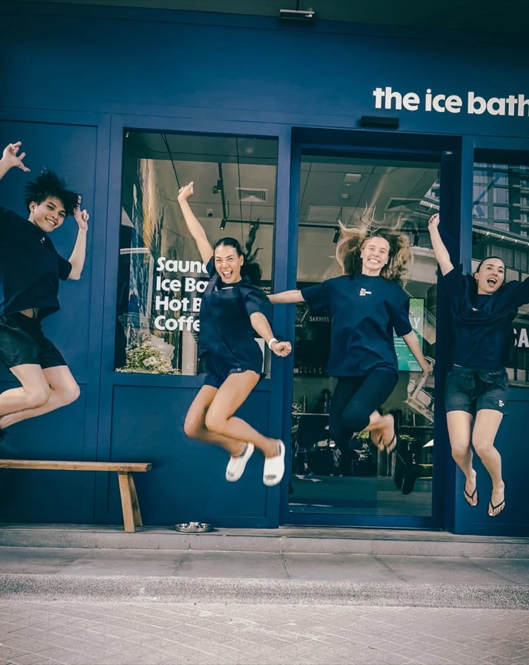 Four of the team jumping outside the club