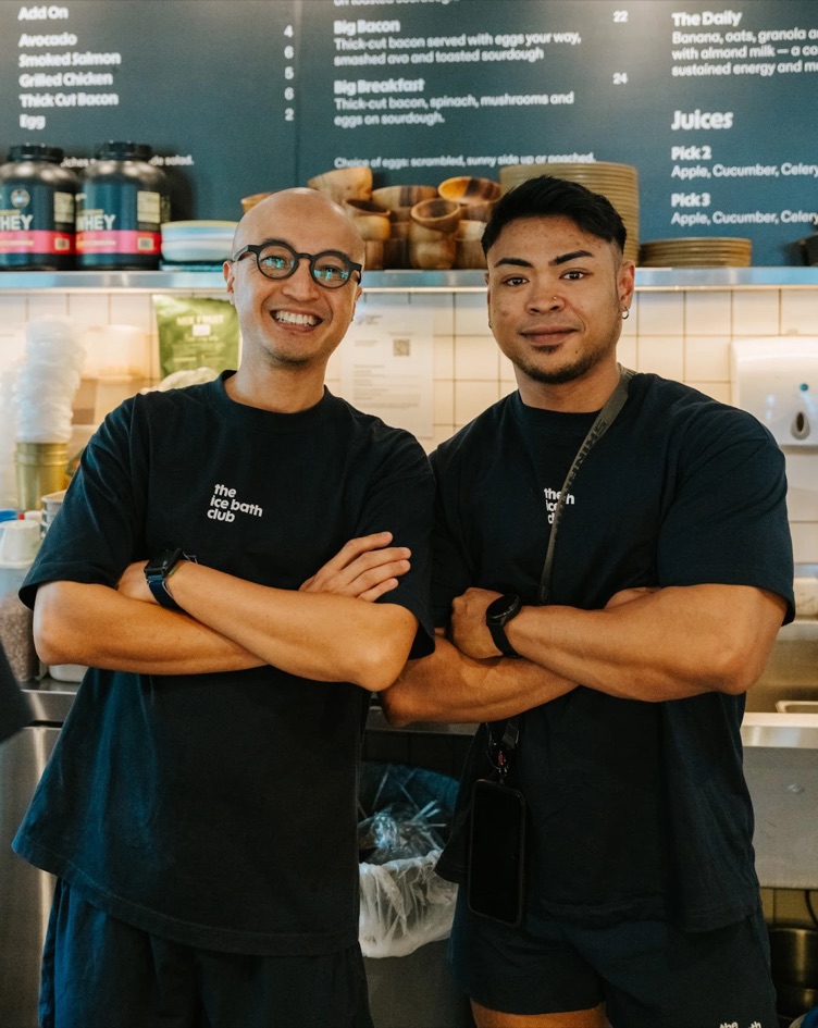 Two of the team, arms crossed, in front of the menu